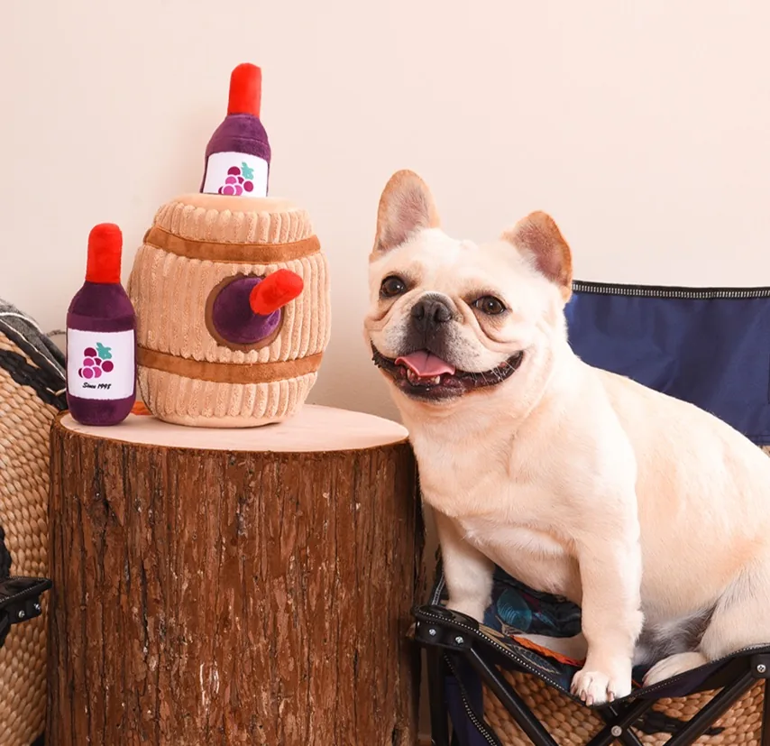 Corduroy wine barrel plush with two wine bottle toys next to a French bulldog
