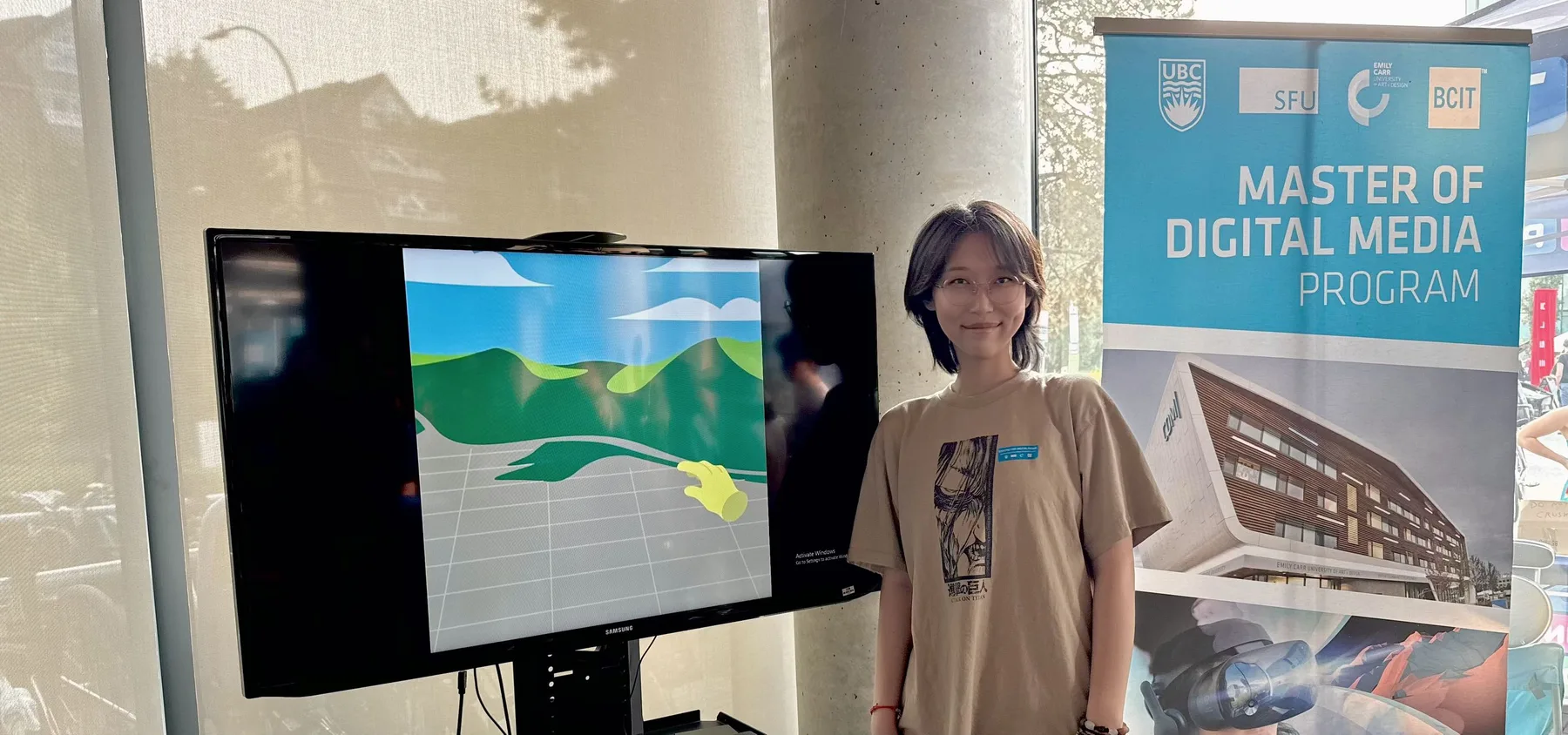 Nicole beside the demo screen at the Master of Digital Media program